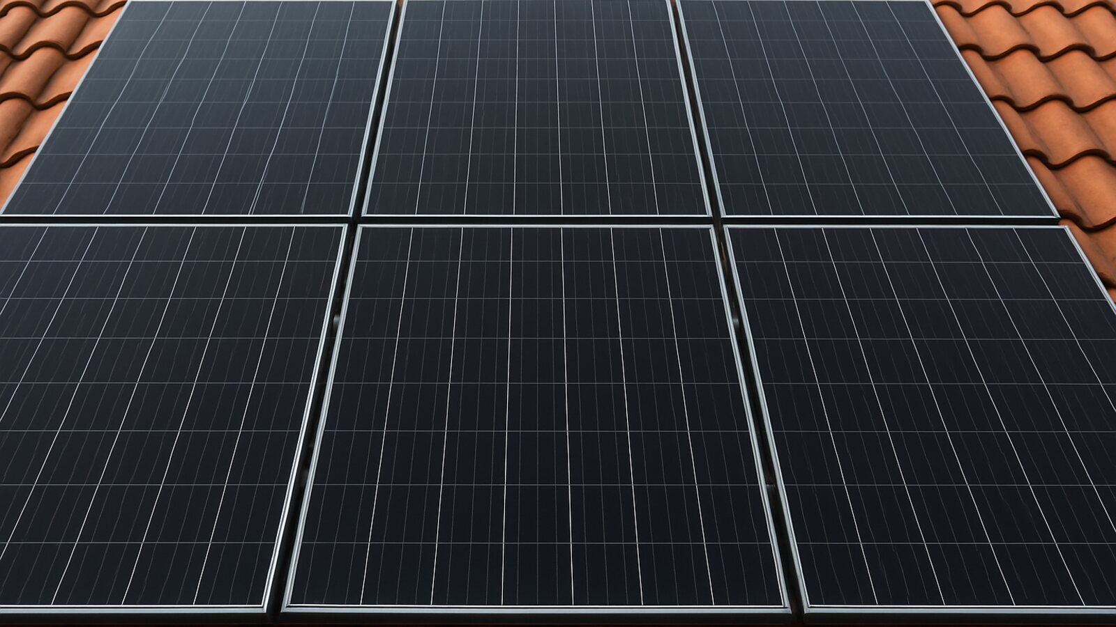 Photovoltaik Datteln: Nahaufnahme mehrerer Reihen fertig montierter schwarzer Solarmodule mit sauberen Fugen auf einem roten Ziegeldach