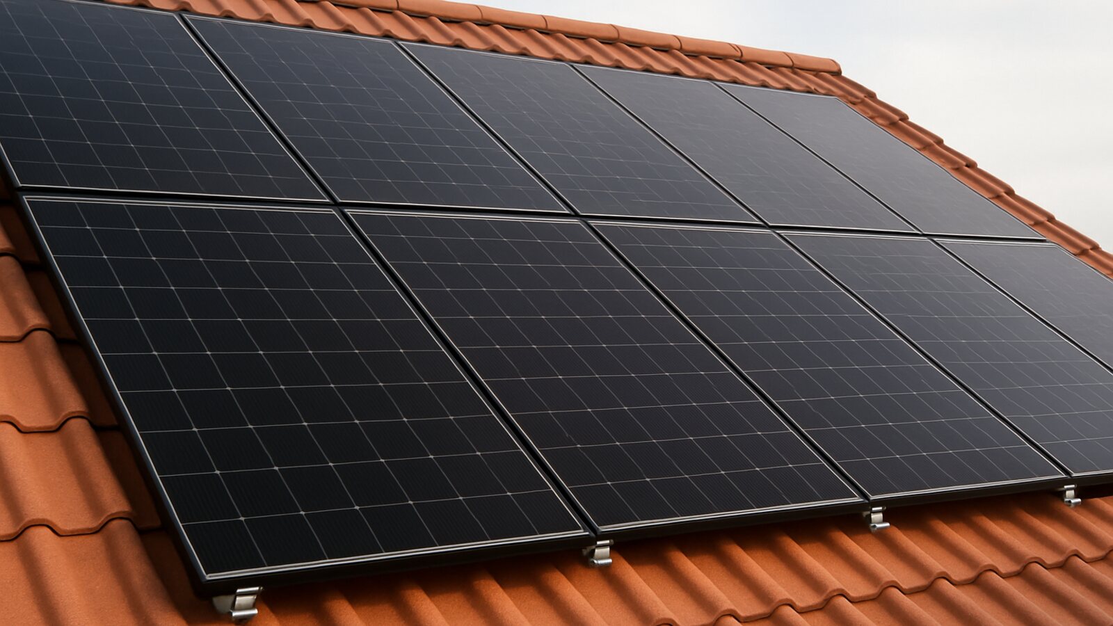 Photovoltaik Herten: Nahaufnahme mehrerer Reihen fertig montierter schwarzer Solarmodule mit sauberen Fugen auf einem roten Ziegeldach