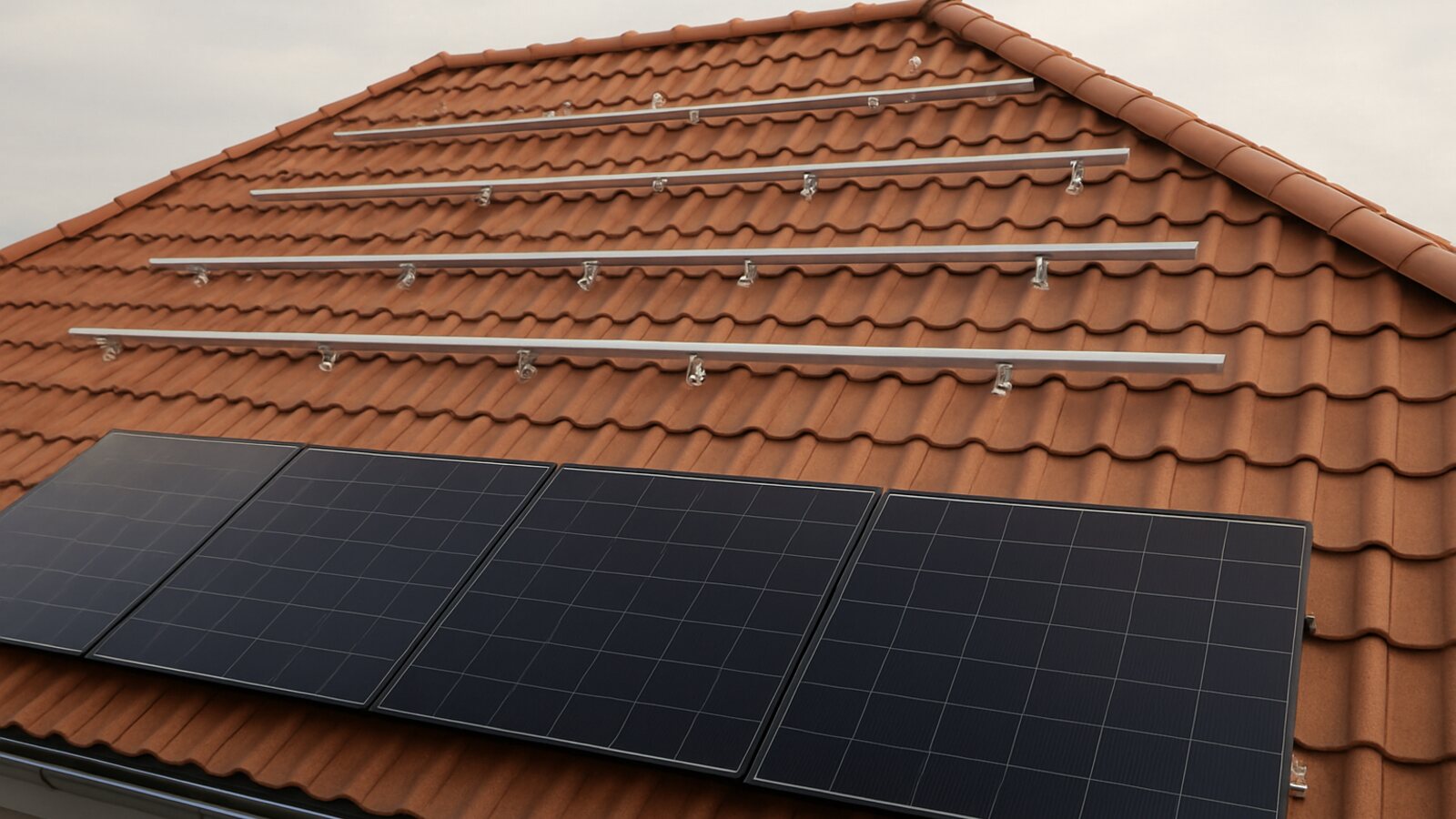 Photovoltaik Marl: halb fertig montierte Anlage auf einem Ziegel-Walmdach, bei der schwarze Module reihenweise auf die silbernen Montageschienen gesetzt werden