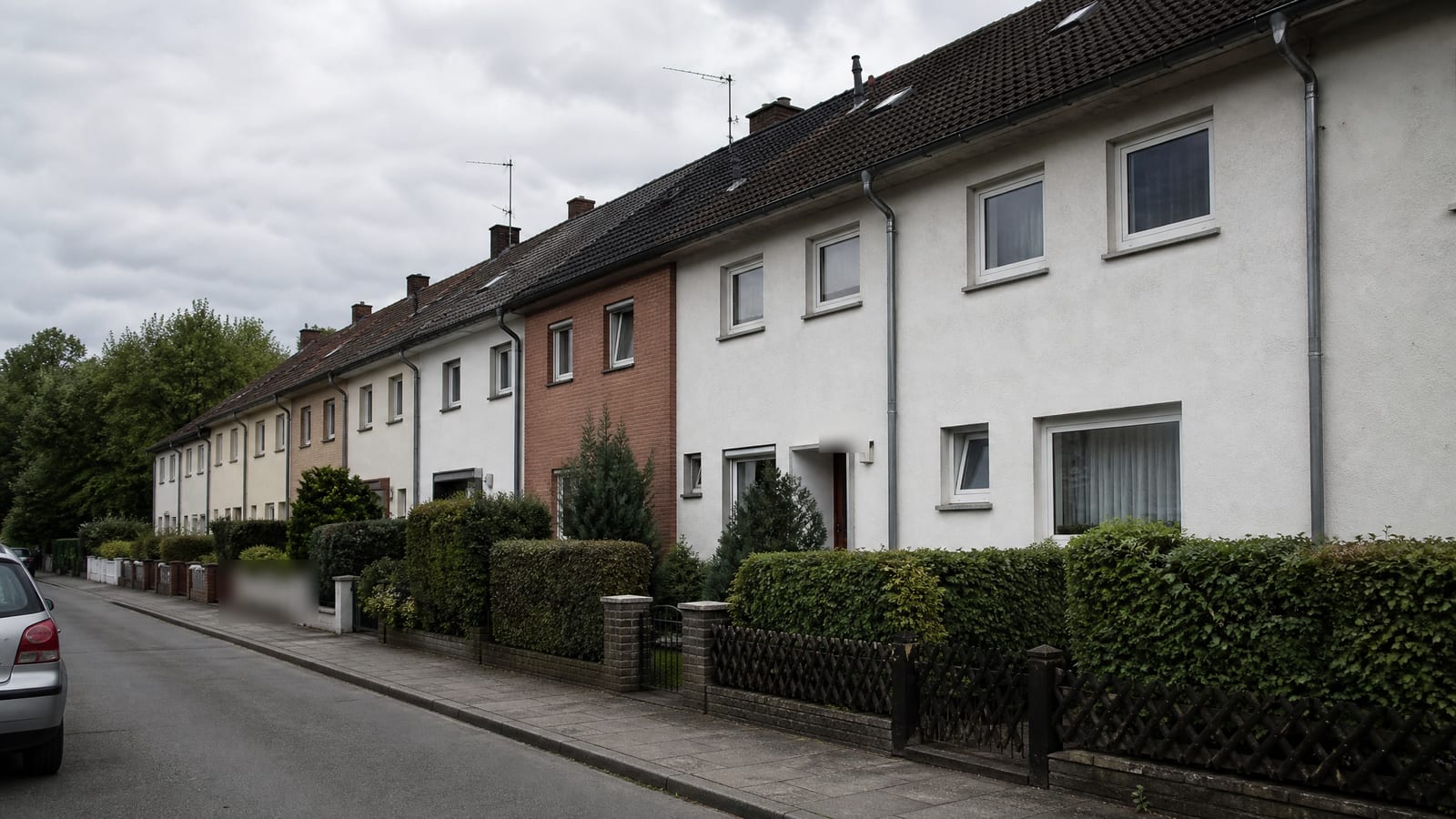 Enge Wohnstraße mit dicht stehenden Häusern, Dachrinnen und Fallrohre Seite an Seite