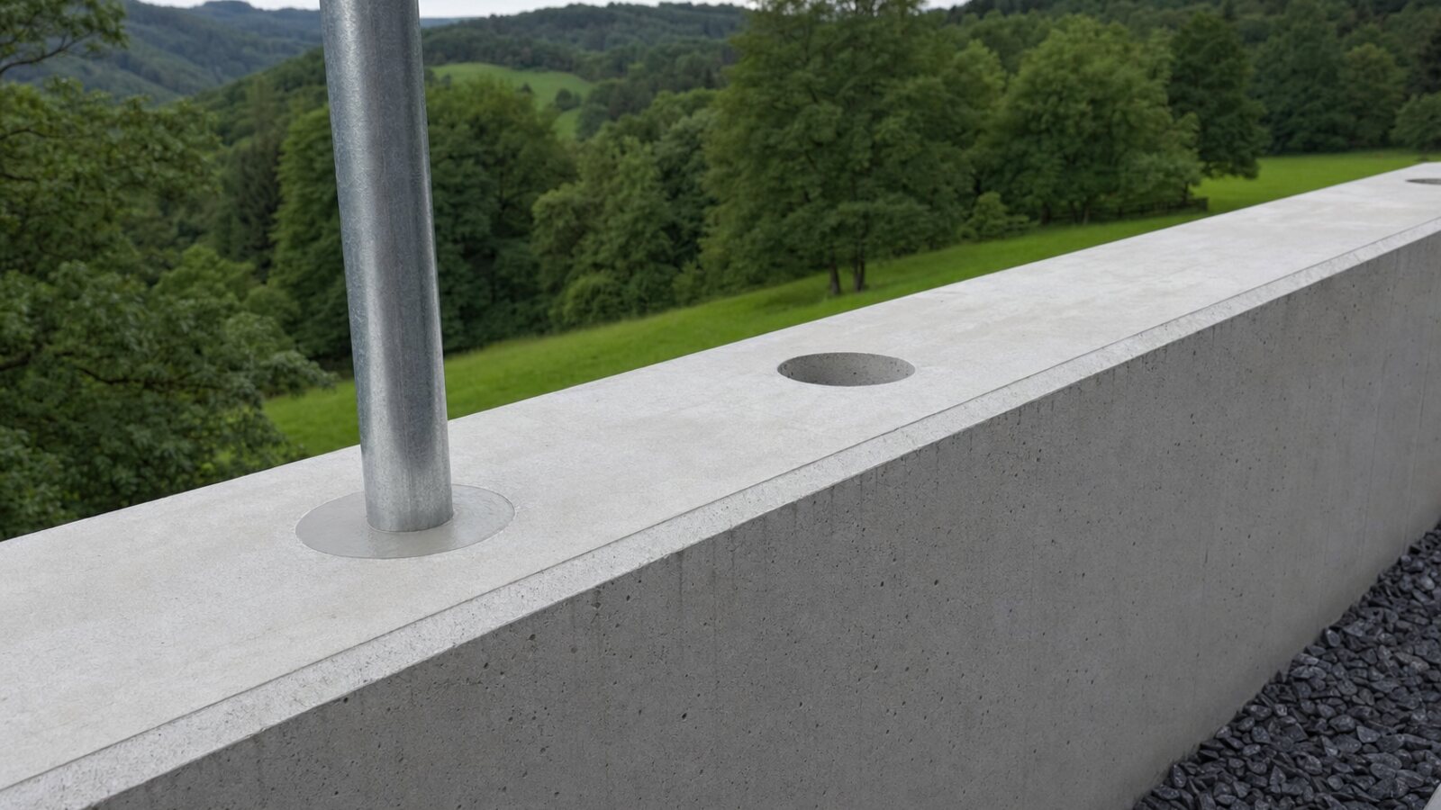 Zaunbau Oer-Erkenschwick: verzinkter Rundpfosten in einer Kernbohrung auf der Krone einer Sichtbetonmauer, mit Vergussmörtel befestigt